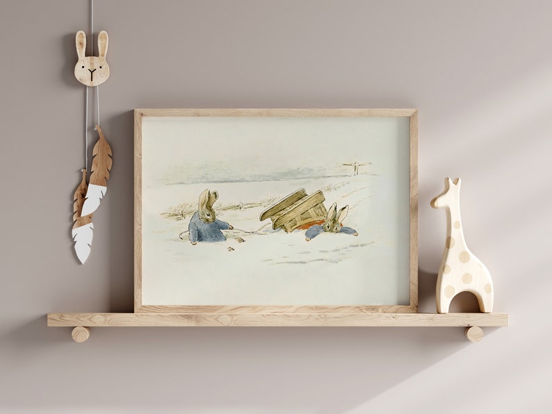 May include: A framed illustration of two rabbits in a snowy landscape. One rabbit is pulling a sled while the other rabbit is sitting in the sled. The sled is tipped over.