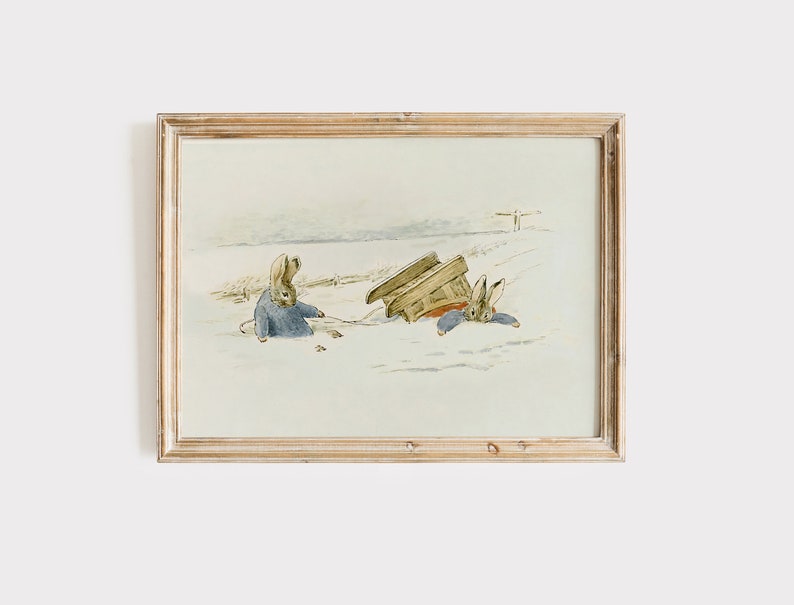 May include: A framed illustration of two rabbits in a snowy landscape. One rabbit is sitting in the snow, while the other is lying on its back with a sled on top of it.