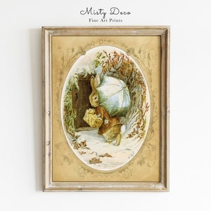 May include: A framed illustration of a rabbit holding an umbrella and a basket, walking through a snowy forest. The illustration is in a gold frame with a decorative border.
