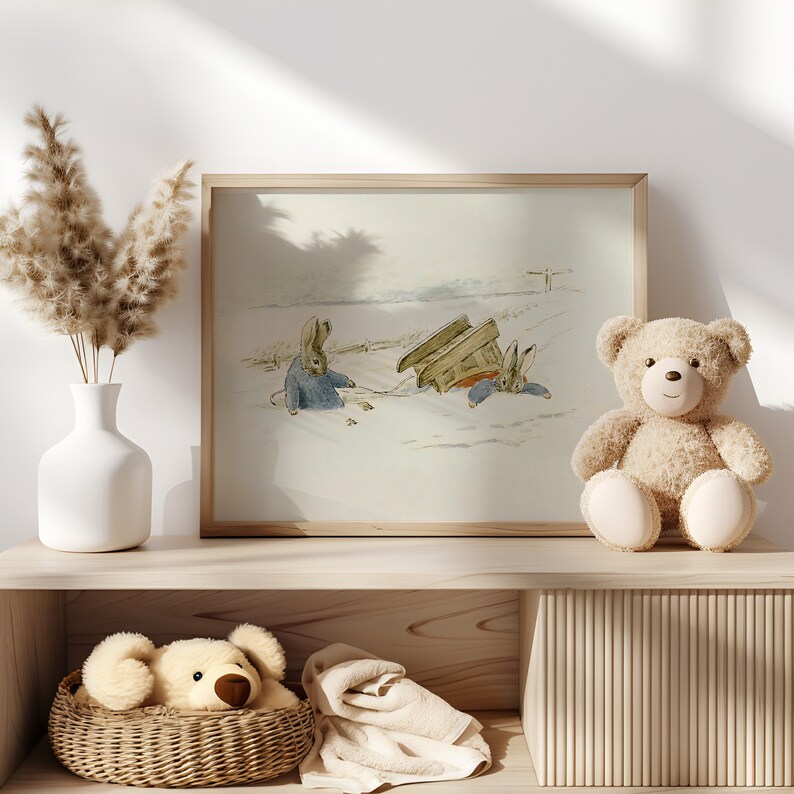 May include: A framed illustration of two rabbits in a snowy landscape. The rabbits are wearing blue clothing and are pulling a wooden sled. A brown teddy bear sits on a wooden shelf below the picture.