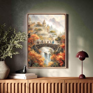 May include: A framed landscape painting depicts a fantasy scene with a stone bridge, waterfall, and castle. The artwork features autumn colors, with orange and red foliage surrounding the bridge. Figures are walking across the bridge.