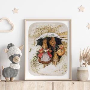 May include: A vintage illustration of two rabbits walking in the snow under an umbrella. The rabbit on the left is wearing a red coat and holding a book. The rabbit on the right is wearing a blue coat and carrying a basket. The illustration is framed in a light wood frame.