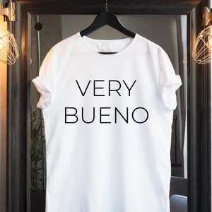 May include: White t-shirt with black text that reads "VERY BUENO".