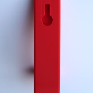 May include: A bright red wooden hook with a round hole in the center. The hook is designed for hanging items on a wall.