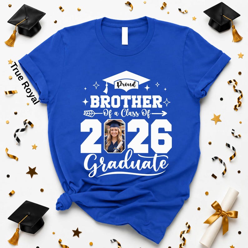 A blue t-shirt with a graduation cap and tassel, surrounded by gold and black confetti, and a graduation cap.
