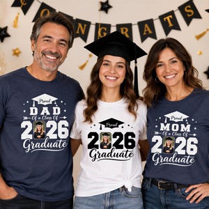 Three people, two women and one man, are standing together and smiling in front of a graduation backdrop. They are all wearing t-shirts with the same design, which features a graduation cap and the text "Graduate" along with the year "2026".