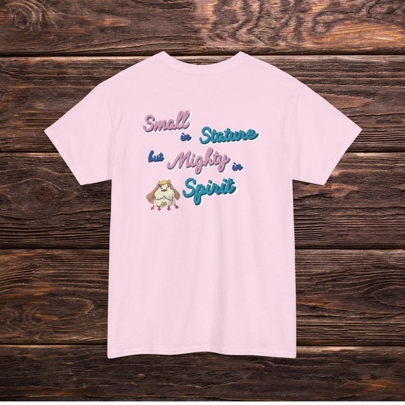 May include: Pink t-shirt with a cartoon animal graphic and the text "Small in Stature but Mighty in Spirit".