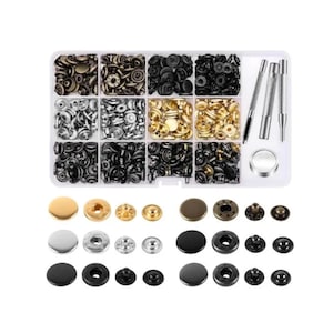 May include: A clear plastic organizer filled with various metal snap fasteners in gold, silver, and black. The kit includes tools for setting the snaps, and a variety of snap styles and sizes.