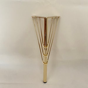 May include: Gold metal table leg with a triangular base and a decorative cage design.