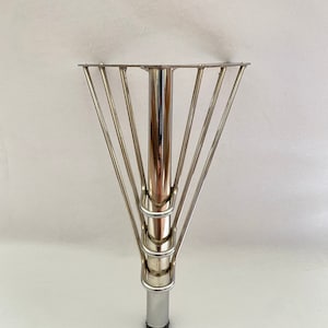 May include: A silver metal table leg with a circular base and a cage-like design around the top.