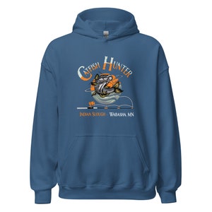 May include: A blue hoodie with a graphic of a catfish jumping out of the water with the text "Catfish Hunter" above it and "Indian Slough - Wabasha, MN" below it.