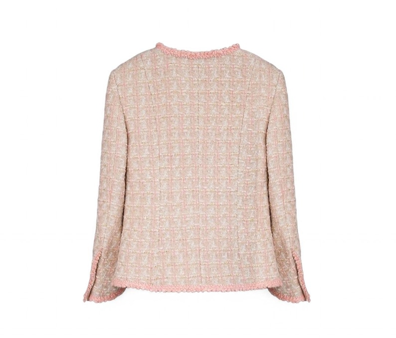 K&ouml;nnte beinhalten: Hellrosa Tweedjacke mit strukturiertem Gewebe. Die Jacke hat lange &Auml;rmel und einen runden Ausschnitt, der mit einem zarten rosa Fransenbesatz versehen ist. Die Manschetten haben ebenfalls ein rosa Fransen Detail. Die Jacke ist ein klassischer Stil.