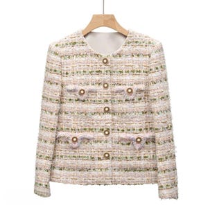 May include: A pink and green tweed jacket with gold button accents. The jacket has a round neckline and long sleeves.