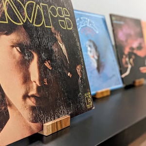 now playing vinyl record stands in a row holding various 12 inch albums