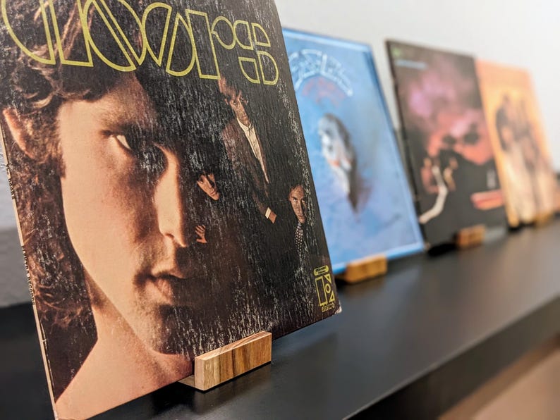 now playing vinyl record stands in a row holding various 12 inch albums