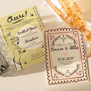 May include: Two wedding invitations with a yellow and pink color scheme. The yellow invitation has the text "Cheers!" and "Cocktail Hour" and "Reception". The pink invitation has the text "Connor & Abby" and "10.10.2024".