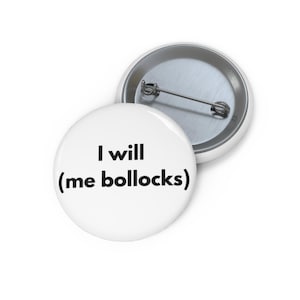 Puede incluir: Dos insignias redondas blancas con respaldos de alfiler metálicos. Una insignia muestra el texto "I will (me bollocks)" en negro. La segunda insignia es parcialmente visible, mostrando el respaldo de alfiler metálico.