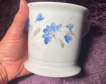 Taza de afeitar antigua de principios del siglo XX con flores azules.