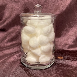 Könnte beinhalten: Ein klares Glasgefäß mit Deckel, gefüllt mit weißen Wattebäuschen.