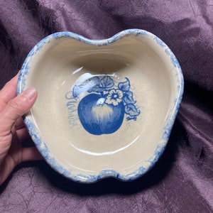 以下が含まれることがあります： 青と白のセラミック製のリンゴ型のボウルで、青いリンゴと花の模様が描かれています。ボウルは波打った縁になっており、スナックやフルーツを盛り付けるのに最適です。