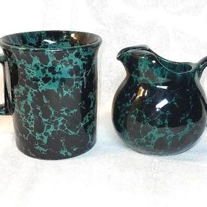 Può includere: Un set di tazza e brocca per la panna in ceramica nera e verde con un design marmoreo.