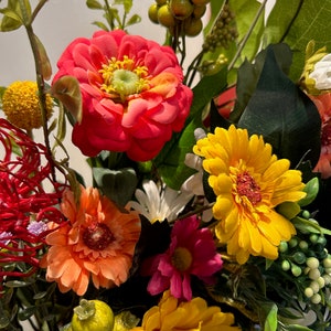 May include: A bouquet of artificial flowers in a variety of colors, including red, orange, yellow, pink, and white. The flowers are arranged in a vase and include daisies, zinnias, and other types of flowers.