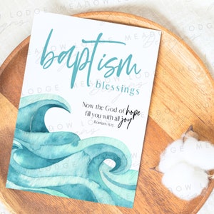 Op de afbeelding: Een witte kaart met blauwe aquarel golven en de tekst "baptism blessings" en "Now the God of hope fill you with all joy" Romeinen 15:13.