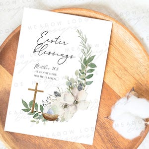 May include: A white card with a watercolor floral wreath and a cross. The text reads "Easter Blessings" and "Matthew 28:6 He is not here: for he is risen."