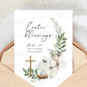 May include: A white card with a watercolor floral wreath and a cross. The text reads "Easter Blessings" and "Matthew 28:6 He is not here: for he is risen."