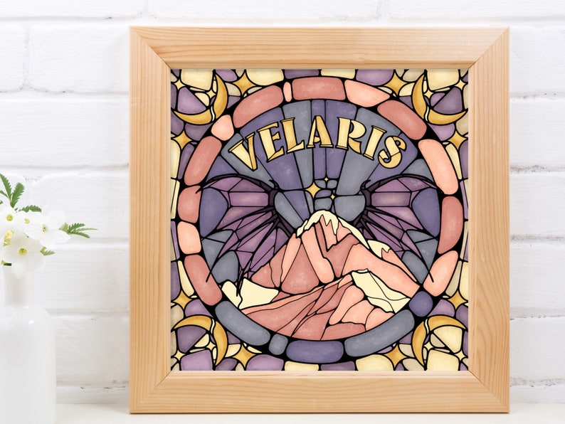 K&ouml;nnte beinhalten: Ein gerahmter Druck mit einem Buntglasdesign, das eine Bergkette, Mondsicheln und das Wort "VELARIS" in goldener Schrift zeigt.