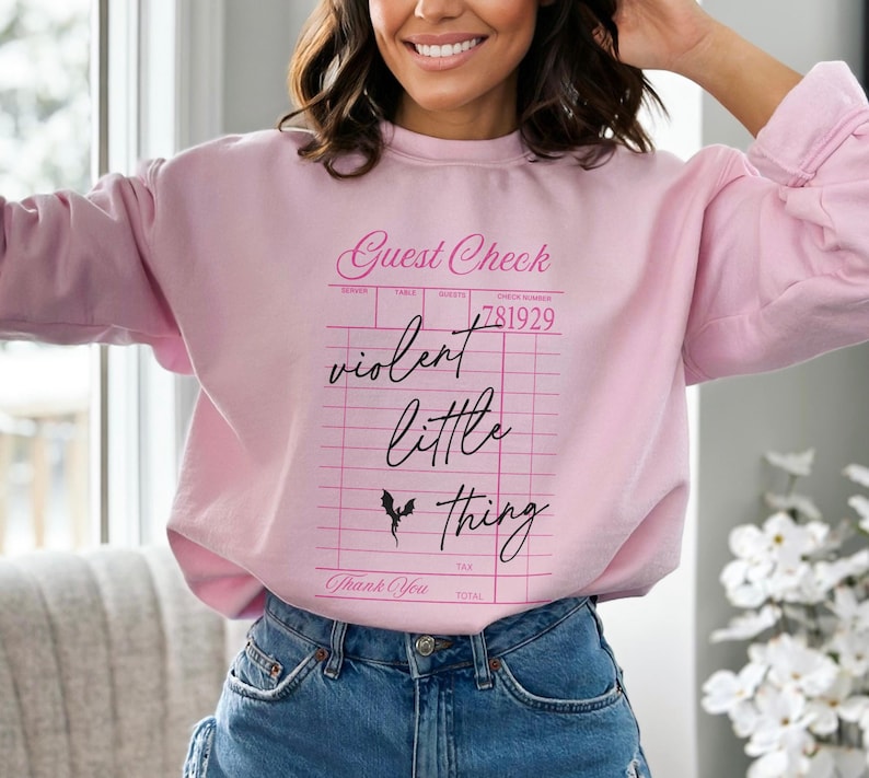 May include: Pink sweatshirt with a graphic of a guest check that says "violent little thing" in pink script with a black bat graphic.
