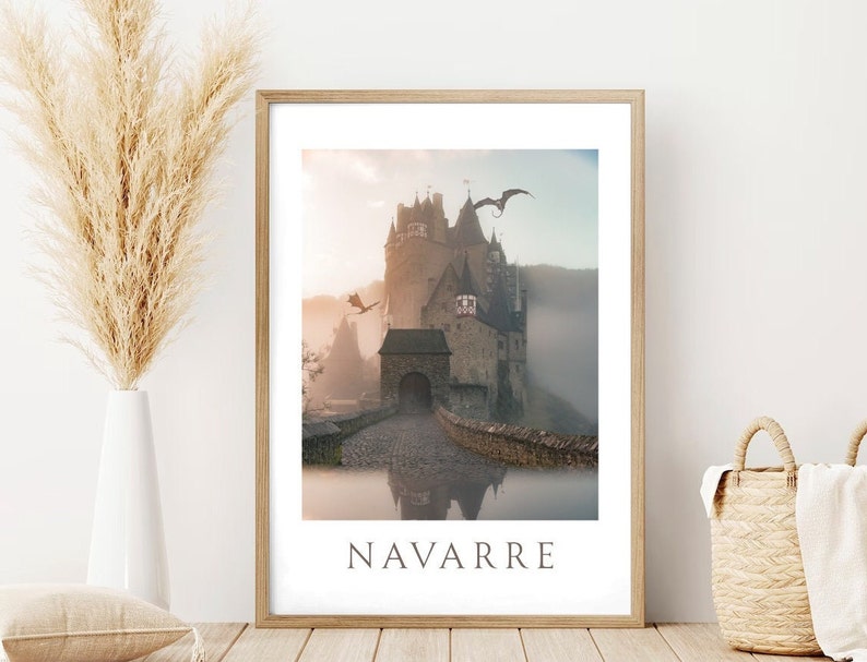 Puede incluir: Una impresi&oacute;n enmarcada de un castillo de piedra con un puente que conduce a la entrada. El castillo est&aacute; rodeado de niebla y dos dragones vuelan por encima. La impresi&oacute;n tiene la palabra "NAVARRE" impresa en la parte inferior.