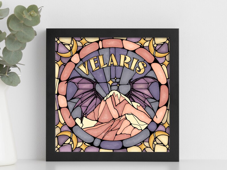 K&ouml;nnte beinhalten: Ein gerahmter Druck mit einem Buntglasdesign, das eine violette und rosafarbene Bergkette mit dem Wort "VELARIS" in goldenen Buchstaben zeigt.