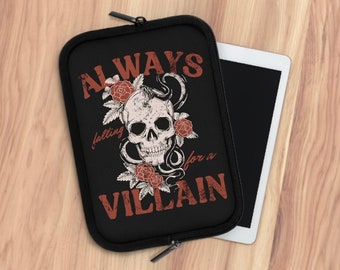 May include: Black laptop sleeve with a skull and roses design. The text "Always falling for a Villain" is printed on the sleeve.