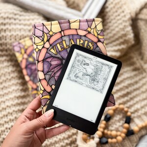 May include: A black Kindle e-reader with a stained glass pattern cover featuring the words "Velaris". The e-reader is displaying a map of the fictional land of Westeros.