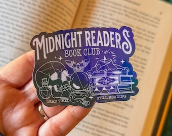 May include: A Midnight Readers Book Club sticker with a dark blue and purple gradient. The sticker features a skull, a crystal ball, books, and the words "Dead Tired" and "Still Reading."