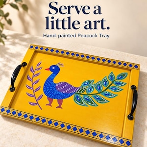 Puede incluir: Una bandeja de servicio rectangular amarilla con un pavo real azul pintado a mano con un ala morada y plumas de cola verdes. La bandeja incluye asas de metal negro a cada lado y un borde geométrico azul. Texto: HANDMADE ART SPACE, Serve a little art., Hand-painted Peacock Tray, DM to order.