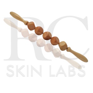 May include: Wooden massage roller with six cube-shaped massage heads and two wooden handles. The roller is made of light and medium brown wood. The product is designed for body massage and relaxation.