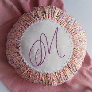 Gesticktes, maßgeschneidertes Buchstabenkissen, gesticktes Monogrammkissen, Rüschenminikissen in Blumenmuster und Weiß.