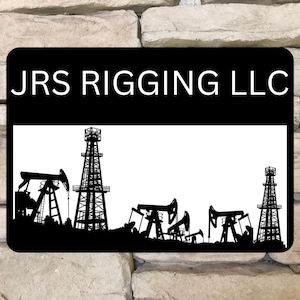 May include: Black and white silhouette of oil rigs against a white background. The sign reads "JRS RIGGING LLC".