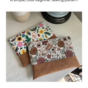 May include: Two floral fabric zipper pouches with brown faux suede bottoms. The pouches are on a light wood surface.