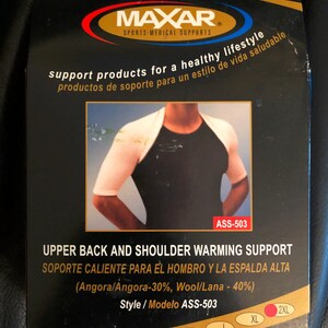 May include: A white upper back and shoulder warming support made of angora and wool. The product is shown on a model wearing a black tank top. The packaging includes the brand name Maxar, the product name, and the style number ASS-503. The packaging also includes size options: S, M, L, XL, and 2XL.