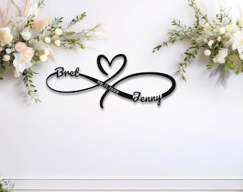 May include: Black metal infinity symbol with a heart in the center. The names "Bret" and "Jenny" are written on either side of the heart, with the date "09.11.1999" inscribed above the heart.