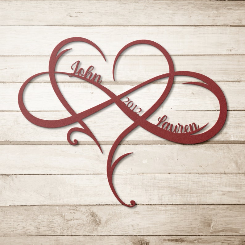 May include: Red metal infinity symbol with a heart in the center. The names "John" and "Lauren" are inscribed on the symbol, along with the year "2012".