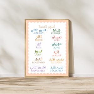 May include: A rectangular wall print featuring a scalloped peach border and a white background. The text displays the twelve months of the year in both Arabic and English, with each month name presented in a unique, colorful watercolor-style font.