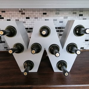 Wine rack in the shape of a w handmade from mdf and painted in a pastel grey holds 9 bottles of wine