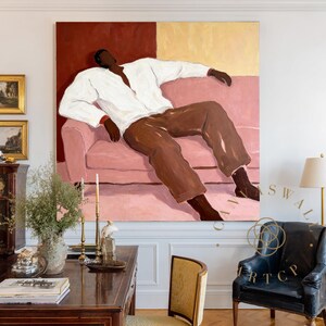 May include: Large abstract painting featuring a figure reclining on a pink sofa. The figure wears a white shirt and brown pants against a backdrop of burgundy and gold. The artwork is displayed in a room with antique furniture and decor.