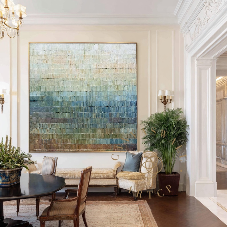 May include: Large abstract painting with a textured surface. The artwork features horizontal bands of color, transitioning from light beige at the top to shades of blue and green, ending with a brown base. The painting is displayed in a well-lit room.