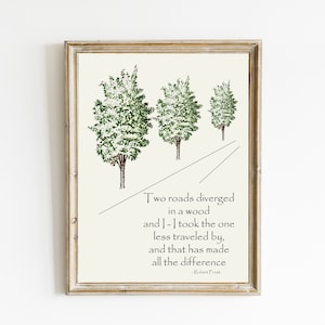 Pode incluir: Uma impressão emoldurada com uma citação do poema de Robert Frost "The Road Not Taken." A citação diz: "Two roads diverged in a wood and I - I took the one less traveled by, and that has made all the difference." A impressão apresenta uma simples ilustração de três árvores e uma estrada.