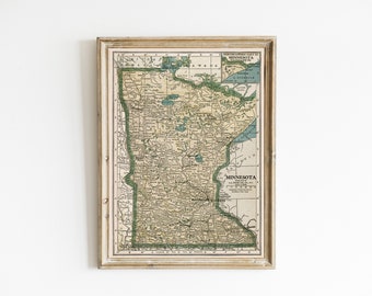 May include: A framed vintage map of Minnesota with a light brown frame. The map is in shades of green, brown, and blue, and shows the state's major cities and towns.